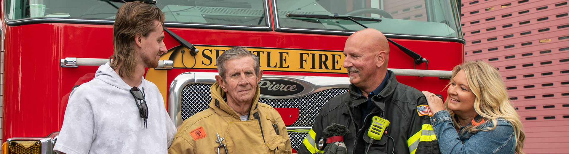 4 people in front of a fire engine