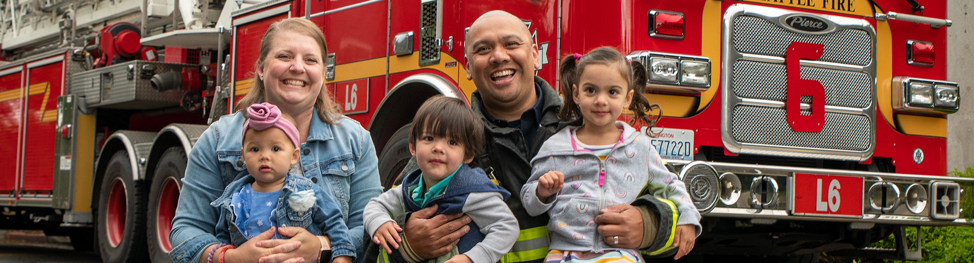 Three fire fighters together in front a a fire truck